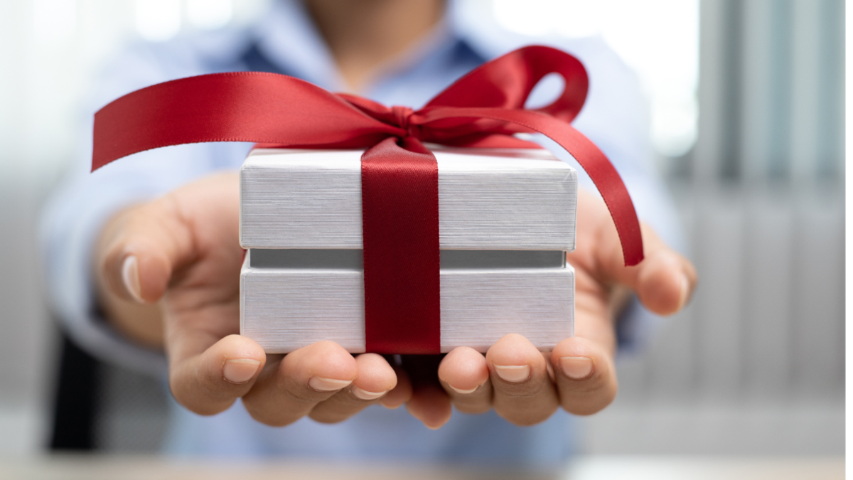 Person handing a small gift box